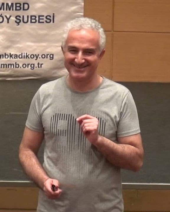 Zafer Yılmaz bir seminerde gülümseyerek konuşurken