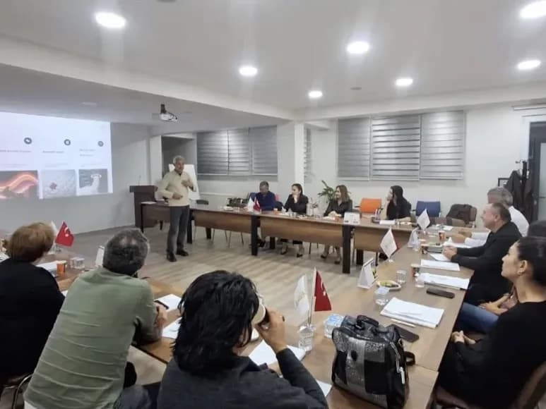 Zafer Yılmaz, ÇAĞSİAD üyelerine sunumun ekranda yansıtıldığı salonda konuşurken